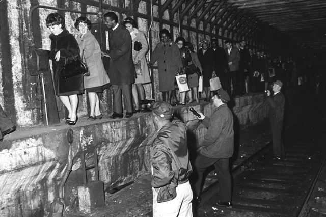 "Helped by railway staff shining torches, passengers make their way along a ledge in a subway tunnel after underground trains had stopped during a power failure in New York." But why is everyone SO HAPPY? November, 1965. (Getty Images)